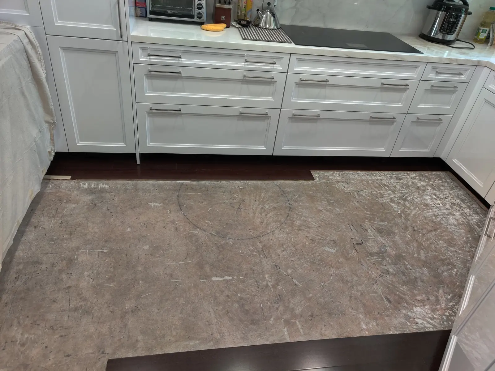 Kitchen flooring selectively removed to expose the substrate during water-damage assessment